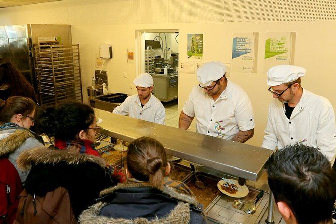 élèves font la queue au self devant les cuisiniers