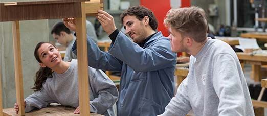 2 jeunes en formation apprennent à construire un objet avec l'aide d'un professeur 